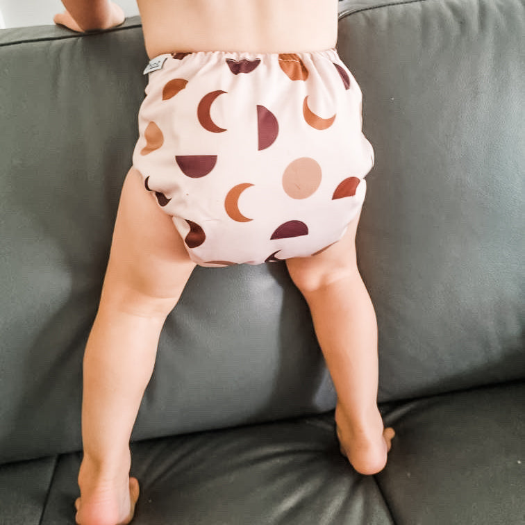 moon phase cloth nappy. Image shows a toddler wearing a moon phase print cloth nappy. 