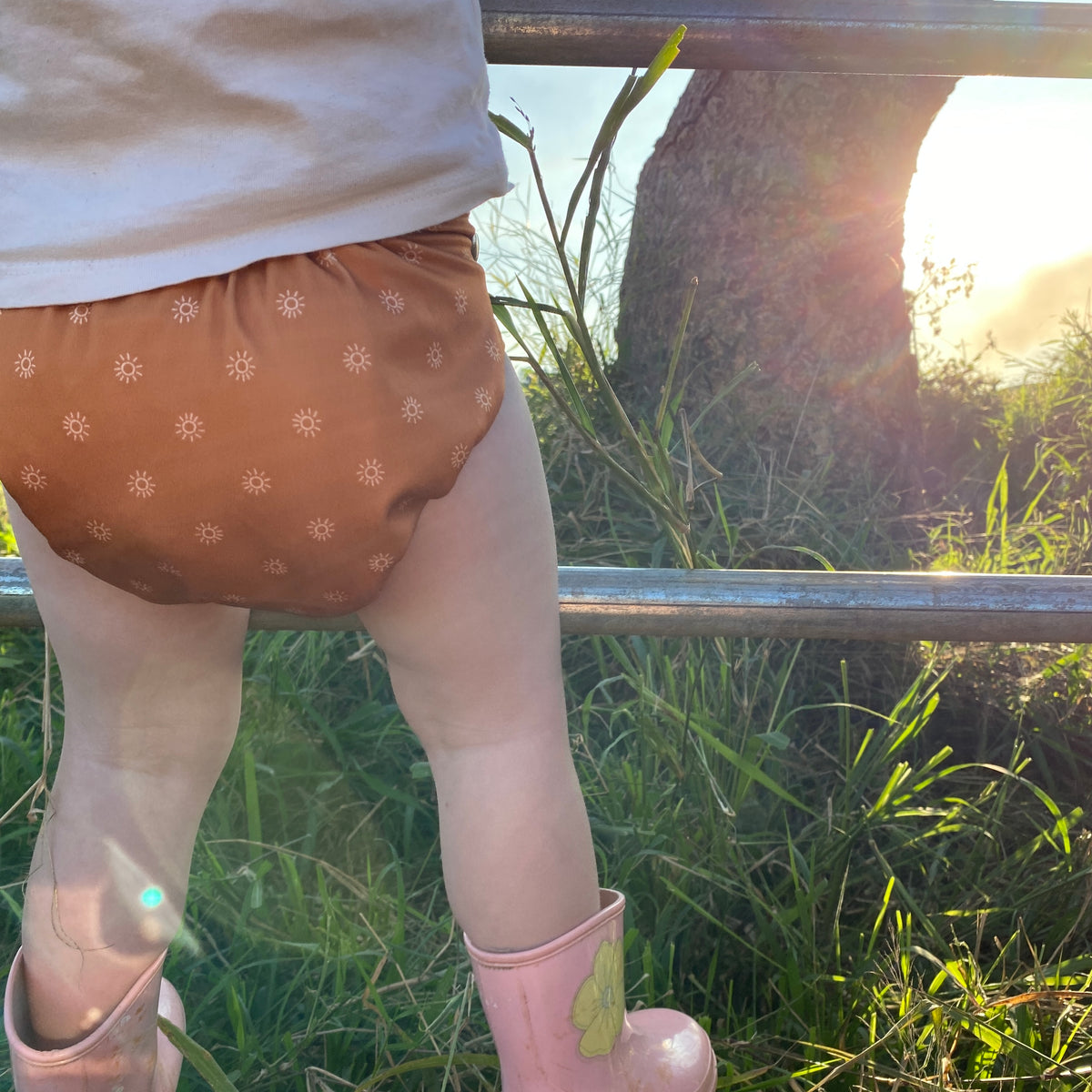 Cloth nappy with neutral tones and cute sun print